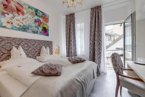a hotel room with two beds and a window at Boutique Hotel Goldenes Lamm Villach in Villach