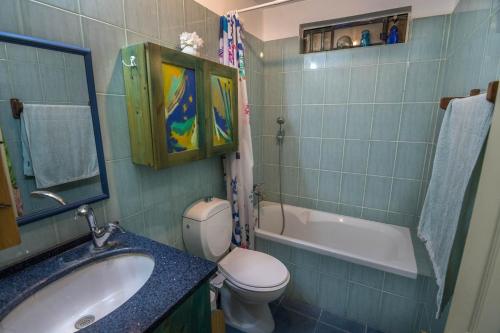een badkamer met een wastafel, een toilet en een bad bij Or Gani in Arad