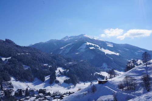 a snow covered mountain with a house on top of it at MyApart Jochberg in Jochberg