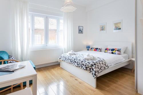 biała sypialnia z łóżkiem i oknem w obiekcie Studio Apartments near park Zrinjevac w Zagrzebiu