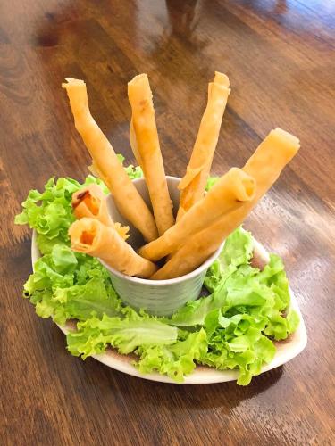 a plate with a bowl of lettuce and french fries at Elliebum Boutique Hotel in Chiang Mai