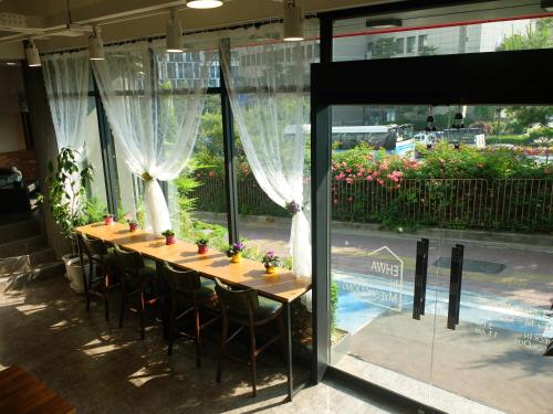 a long table with chairs in front of a window at Ehwa In Myeongdong in Seoul