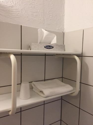 a shelf in a bathroom with towels on it at Hotel Laasby Kro in Låsby
