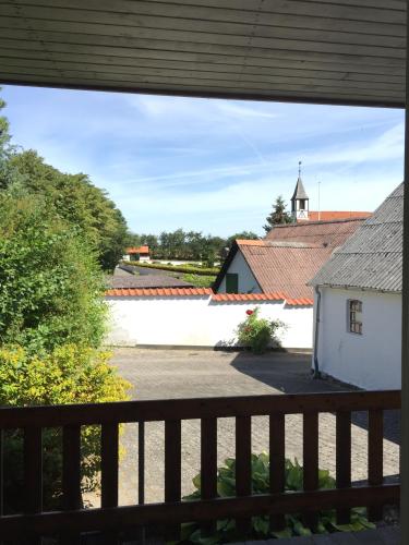 a view from the porch of a house with a church at Hotel Laasby Kro in Låsby
