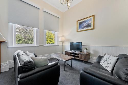 a living room with two couches and a tv at Waratah On York in Launceston