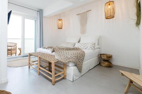 a white bedroom with a bed and a table at San Michele in Procida