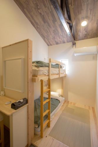 a room with bunk beds and a desk and a computer at I Osaka Traditional in Osaka