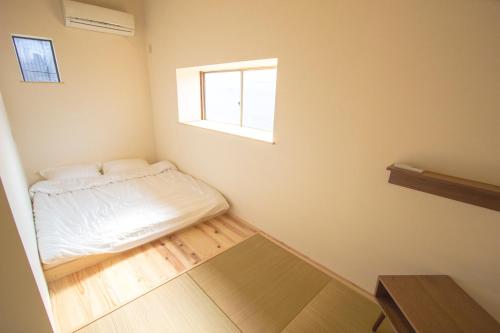 a small bedroom with a bed and a window at I Osaka Traditional in Osaka