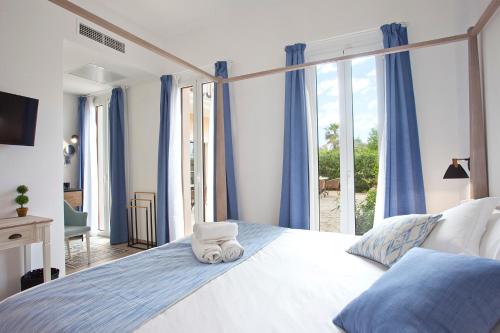 Boutique Hotel Petit Sant Miquel في Calonge: غرفة نوم بسرير كبير عليها مناشف