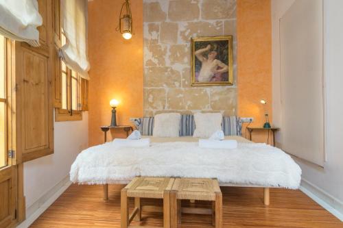 a bedroom with a large bed with a stone wall at Miraclet - ADULTS ONLY in Palma de Mallorca