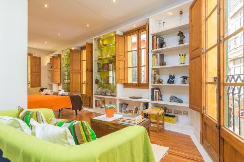 a living room with a green couch and a bed at Miraclet - ADULTS ONLY in Palma de Mallorca
