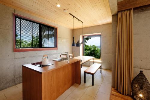 uma casa de banho com uma secretária, um lavatório e uma janela em Kaiza em Nanjo
