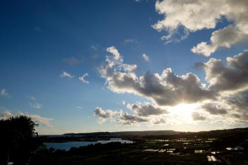 a view of the sky with the sun hiding behind clouds at Kaiza in Nanjo