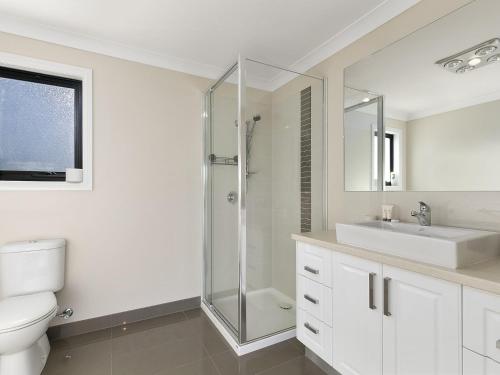 a white bathroom with a sink and a shower at SUMMER BREEZE FREE WIFI & NETFLIX INLET SIDE CENTRAL LOCATION in Inverloch