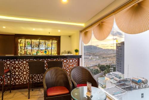 a restaurant with a bar with chairs and a view at Regalia Nha Trang in Nha Trang