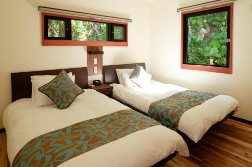 a hotel room with two beds and two windows at Kaiza in Nanjo