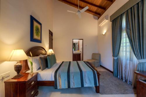 a bedroom with a bed and a chair and a window at Hanthana Boutique Villa by Amaya in Kandy