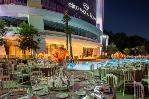 a restaurant with tables, chairs and umbrellas at Elite World Europe Hotel in Istanbul