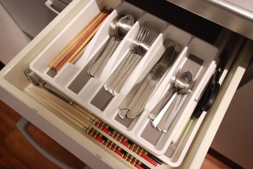 a white tray with utensils in a drawer at Yamaguchi House Annex, Private House with Onsen in Hakone