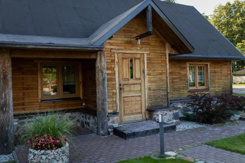a wooden house with a porch and a door at Erlendi Kodumajutus in Pärnu