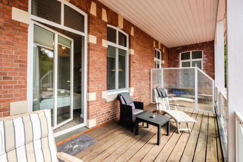 a porch with two chairs and a bench on it at Das 53°Hotel in Bad Zwischenahn