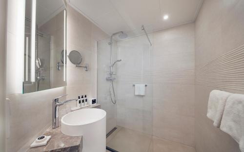 a bathroom with a shower and a toilet and a sink at WestCord Hotel Noordsee in Nes