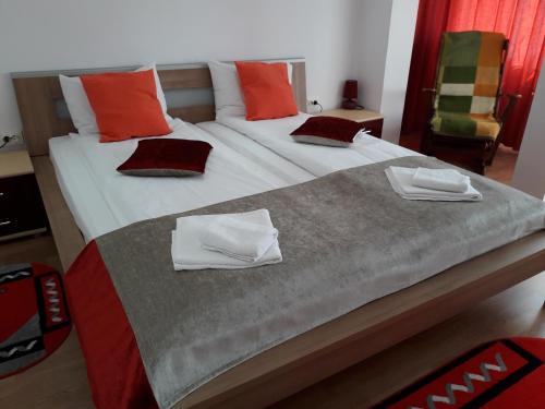 una camera da letto con un grande letto con cuscini rossi di Mary Apartment a Sibiu