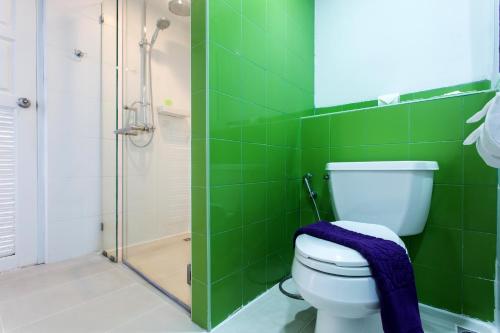 a green tiled bathroom with a toilet and a shower at Samui Verticolor in Chaweng