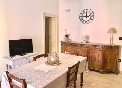 una sala da pranzo con tavolo e TV di Casa Vacanze Il Pumo a Corsano