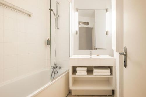 uma casa de banho com um lavatório e um chuveiro em Citadines Austerlitz Paris em Paris