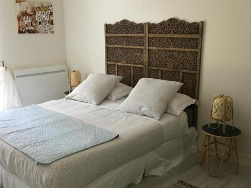 een slaapkamer met een groot bed met witte lakens en kussens bij Domaine en castanet in Caraman