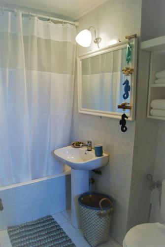 a bathroom with a sink and a shower with a mirror at the bougainvillea house in Symi