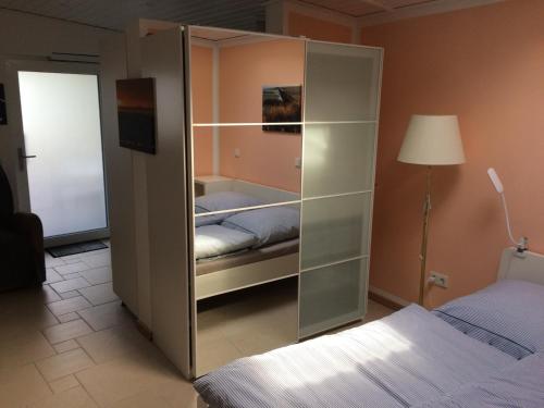 een slaapkamer met een glazen kast en een bed bij Deichkutscher in Schmarren