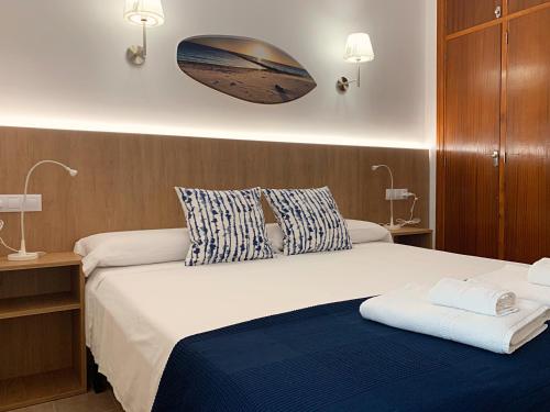 a bedroom with a large bed with a blue blanket at Casa Coromines in Alcudia