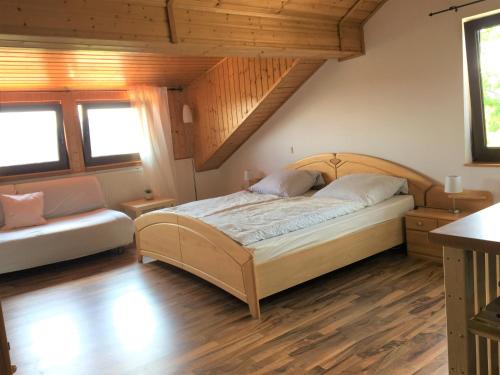 a bedroom with a bed and a couch at Ferienhaus am Kagerstein in Neukirchen beim Heiligen Blut