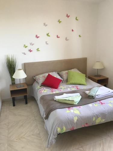 - une chambre avec un lit aux papillons sur le mur dans l'établissement Appartements La Fossette plage, au Lavandou