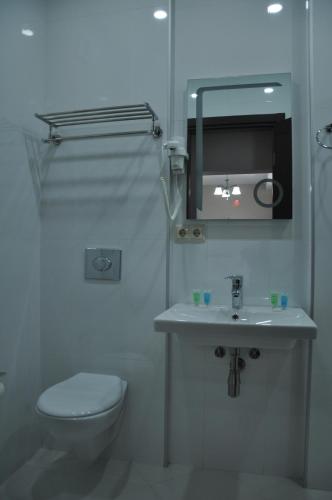 a bathroom with a toilet and a sink and a mirror at Dream Tower in Batumi