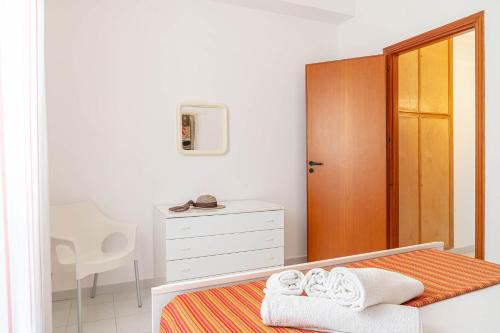 a bedroom with a bed with towels on it at Palms Villa in Scopello