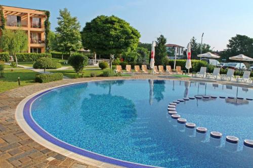 a large swimming pool with chairs and a building at Lux Sozopoli Hills Apartments A19 и Studio А13 in Sozopol