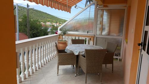 a balcony with a table and chairs and a window at Apartments Anka in Vinišće