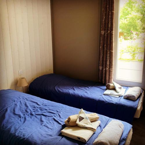 deux lits dans une chambre avec des serviettes dessus dans l'établissement Chalet 2 chambres en Bois dans les landes n34, à Tosse