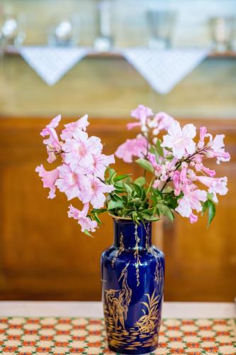 a blue vase filled with pink flowers on a table at Kiko, the Coastline house in Kato Achaia