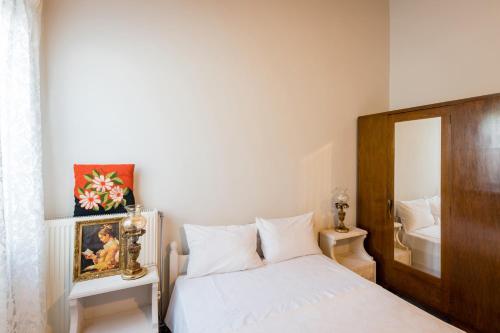 a bedroom with a white bed and a mirror at Kiko, the Coastline house in Kato Achaia