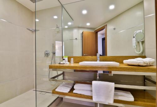 a bathroom with a sink and a shower at Hotel Le Fouquet's in Cannes