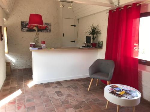 a room with a counter and a chair and a table at Hotel The Originals Le Manoir de Pierre Levée in Tournon-Saint-Martin