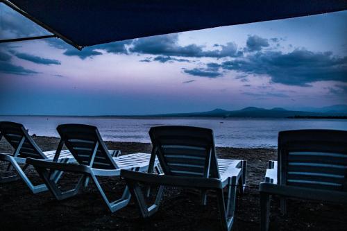 three lawn chairs sitting on the beach at dusk at Garden Inn Resort Sevan in Sevan