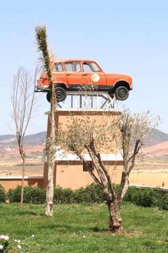 a car on top of a building with a tree at Hotel Meteorites Boulaajoul in Zaida