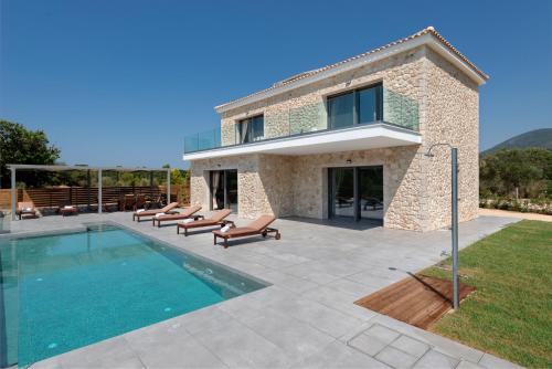 een huis met een zwembad naast een gebouw bij Kefalonia Stone Villas - Villa Petros Kefalonica in Trapezaki