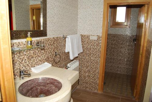 a bathroom with a sink and a shower at Hotel Meteorites Boulaajoul in Zaida
