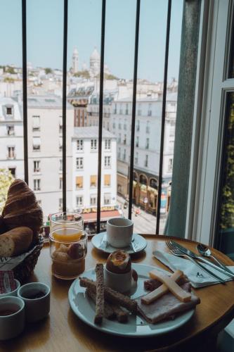 - une table avec petit-déjeuner et une vue sur la ville dans l'établissement La Villa Royale, à Paris